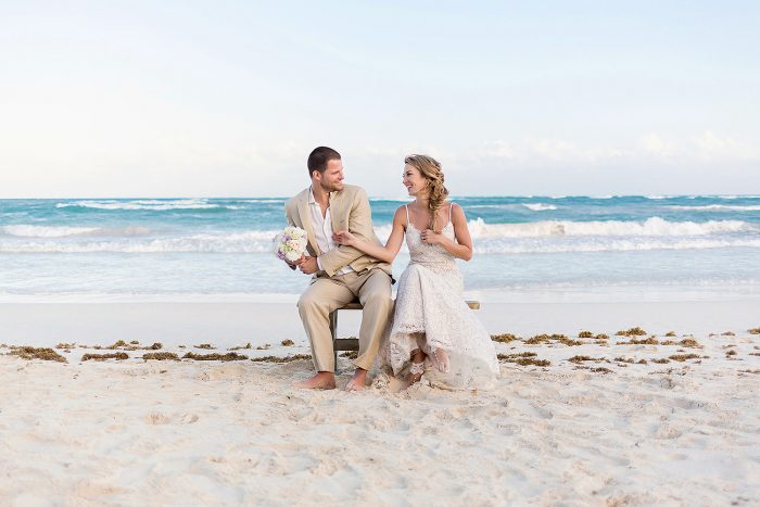 Bride and groom having fun on bench an beach in Tulum