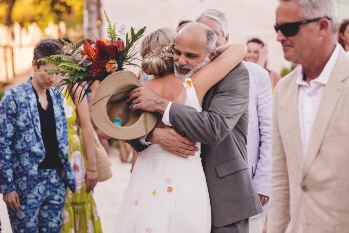 Bride getting hug from guest at wedding in Cancun