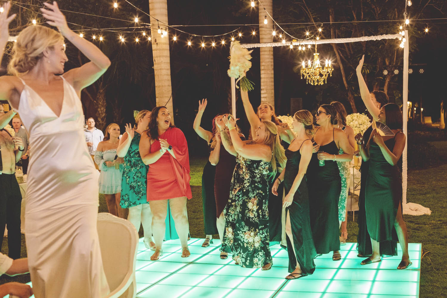 Girls catching bouquet at wedding reception.